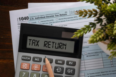 Calculator with text Tax Return, 1040 individual tax form at the