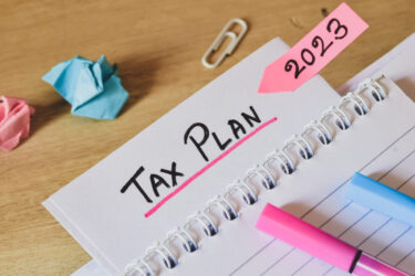 Tax plan for the year 2023 concept. Handwritten text on desk. Se